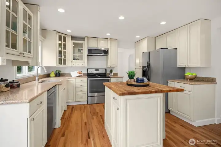 Another angle of the kitchen showcasing the butcher block island, generous counter space, and classic white cabinetry that make this a truly functional and inviting heart of the home. Another angle of the kitchen showcasing the butcher block island, generous counter space, and classic white cabinetry that make this a truly functional and inviting heart of the home.