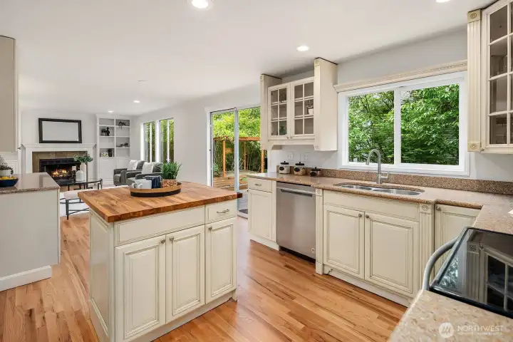 Sun filled kitchen with large windows overlooking the lush backyard, featuring the butcher block island, hardwood floors, and ample cabinetry for effortless everyday living. Sun filled kitchen with large windows overlooking the lush backyard, featuring the butcher block island, hardwood floors, and ample cabinetry for effortless everyday living.