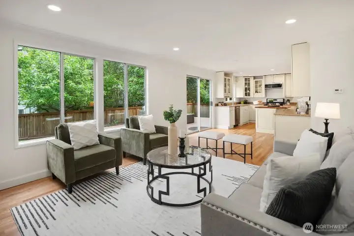 Light filled family room with views into the kitchen and lush backyard greenery beyond, showcasing the bright open flow of the main living level. Light filled family room with views into the kitchen and lush backyard greenery beyond, showcasing the bright open flow of the main living level.