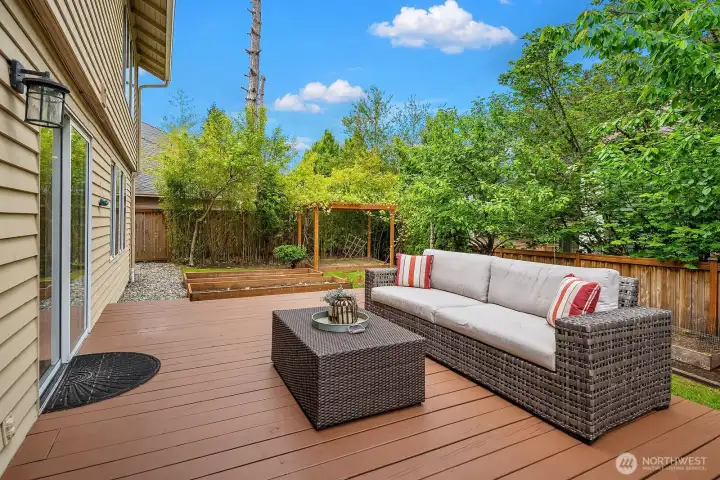 Inviting deck with comfortable outdoor seating surrounded by mature trees and lush greenery, creating a private and serene backyard oasis perfect for relaxing and entertaining. Inviting deck with comfortable outdoor seating surrounded by mature trees and lush greenery, creating a private and serene backyard oasis perfect for relaxing and entertaining.