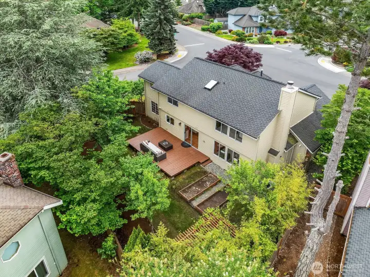 Overhead aerial view highlighting the home's spacious deck, fully fenced backyard, mature fruit trees, and desirable corner lot setting within the Klahanie neighborhood. Overhead aerial view highlighting the home's spacious deck, fully fenced backyard, mature fruit trees, and desirable corner lot setting within the Klahanie neighborhood.