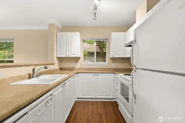 Kitchen features white cabinetry and appliances for a cohesive style.