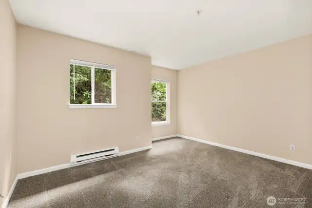 Primary bedroom sits at back of condo, making it a quiet retreat with green views.