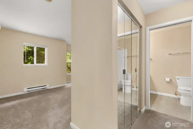 View of primary, looking down to private ensuite. This bedroom offers closet (shown) and a large walk-in closet across the hall.