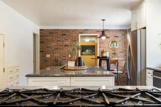 The chef’s kitchen is a showstopper, featuring granite counters, a premium gas range, and an oversized walk-in pantry—perfect for entertaining or farm-to-table cooking using your own fresh-picked produce from established fruit trees, berries, grapevines, and raised garden beds.