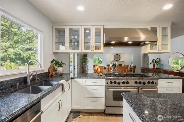 The kitchen windows span the views of the back forest bringing the lush green into the home.