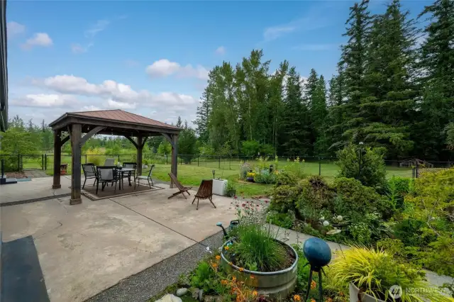 The expansive back patio overlooks the back forested acreage and is fully fenced in.