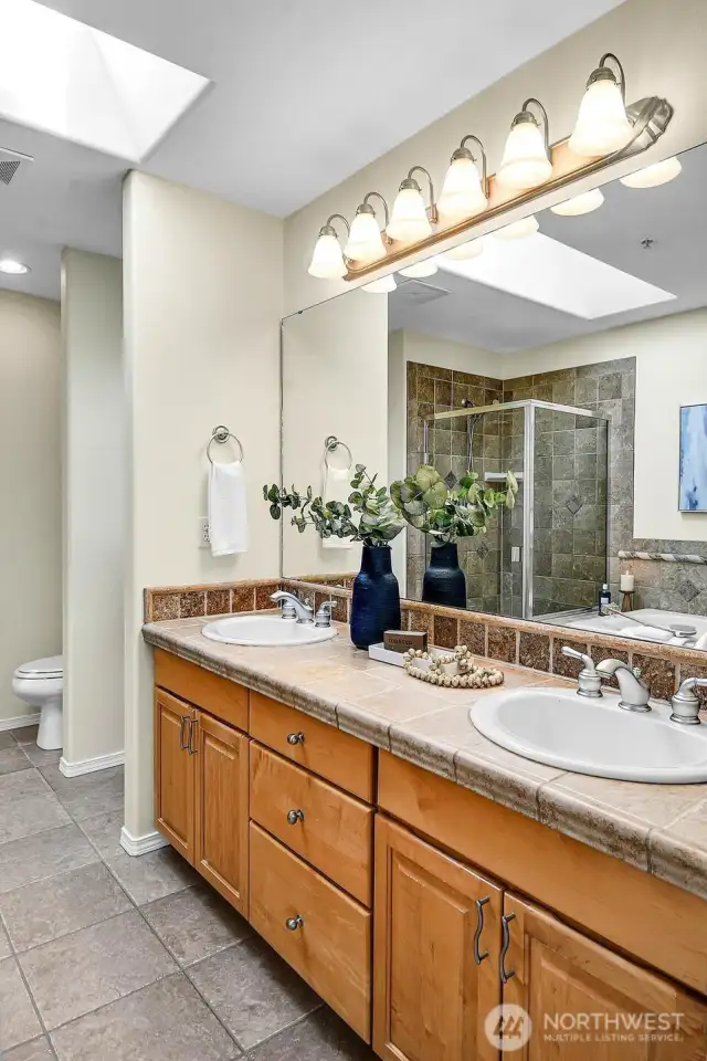 The built-in bench is in the nook just to the left of this grand double-vanity.