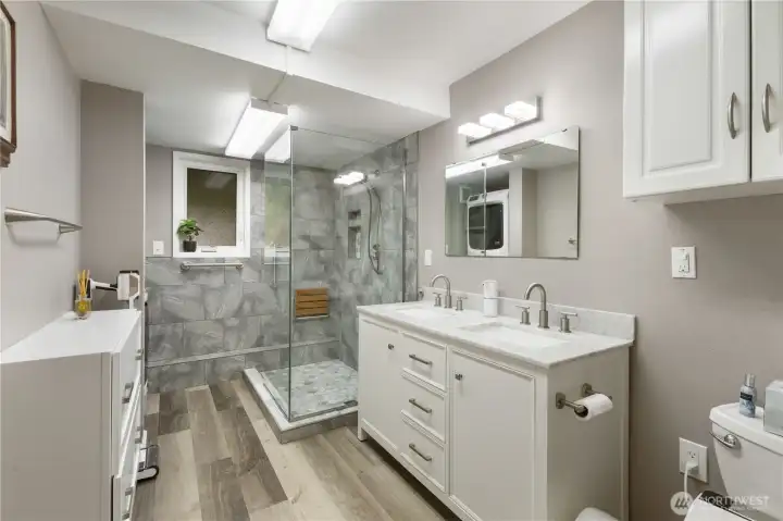 Recently remodeled downstairs bath includes double vanity and generous glass shower.