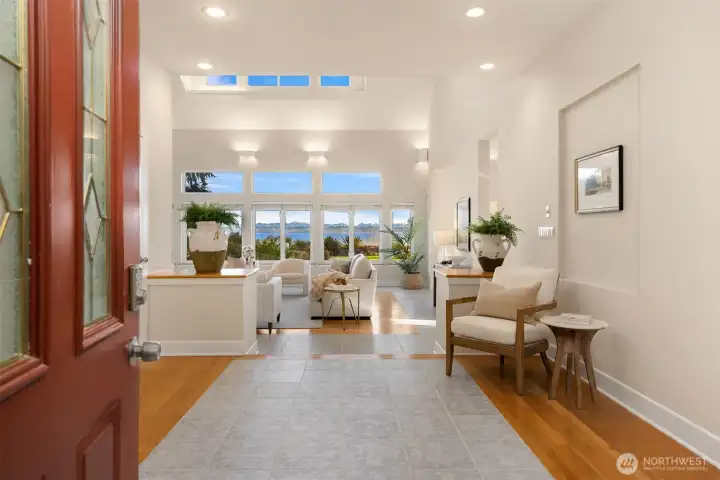 Welcoming entry with soaring ceilings and large windows that frame the water view and fill the main living space with natural light.