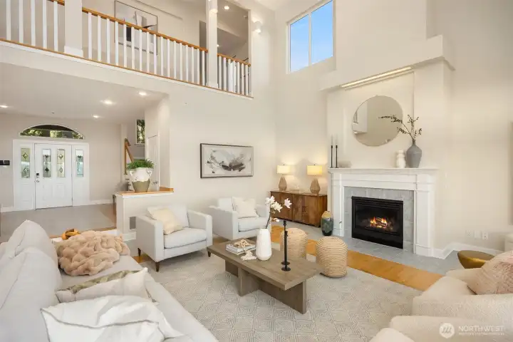 Spacious main living area with fireplace, upper-level overlook, and tall ceilings that enhance the home’s open and airy design.