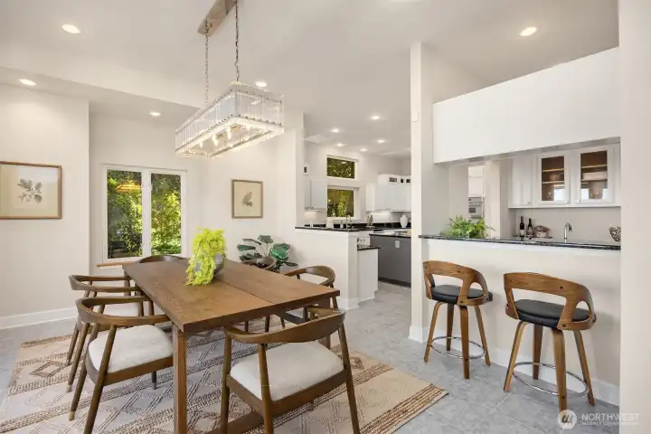 Dining area with statement lighting opens to the kitchen and wet bar, offering functional flow for daily living and entertaining.