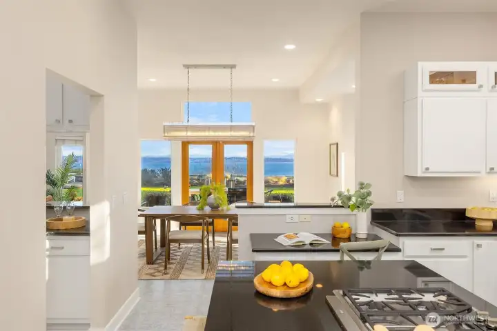 Kitchen with generous counter space and sightlines to the dining area and water view, creating a bright and connected main level layout.