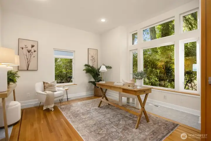 Main floor bedroom located just off the kitchen and main entry. Currently staged as a home office with large windows and flexible use potential.