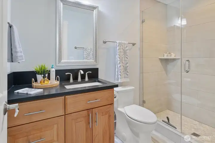 Black quartz and fully tiled shower in every bathroom in this home