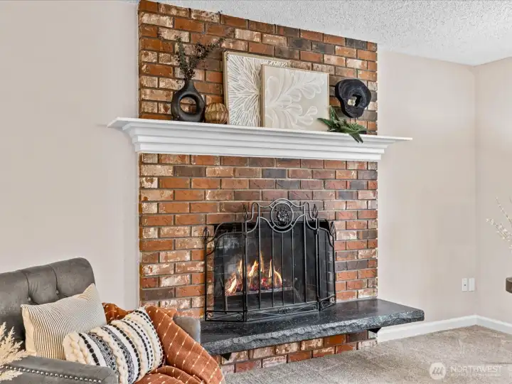 A classic brick fireplace anchors the living room — the perfect place to gather on cool Northwest evenings.