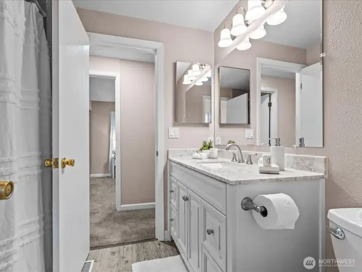 The updated bathroom connects with the primary bedroom for an en-suite experience.