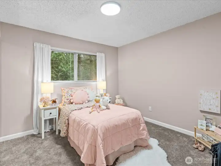 A comfortable bedroom filled with natural light.