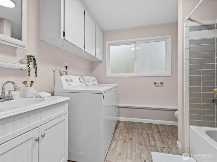 A full bath and laundry area are combined on the lower level.