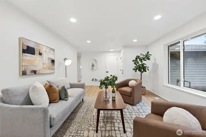 Another angle showcases the living room's spacious layout and neutral palette, with LVP flooring and a clear sightline down the main hallway.