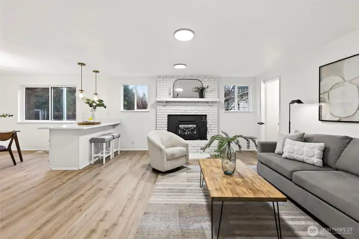 Open-concept flow connects the family room to a sleek white bar peninsula with seating and globe pendant lighting, making this space as functional as it is inviting.