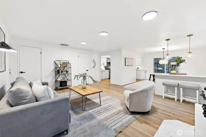 The open-concept design shines here, with the family room flowing effortlessly into the kitchen and dining space, all tied together by warm LVP flooring and consistent finishes throughout.