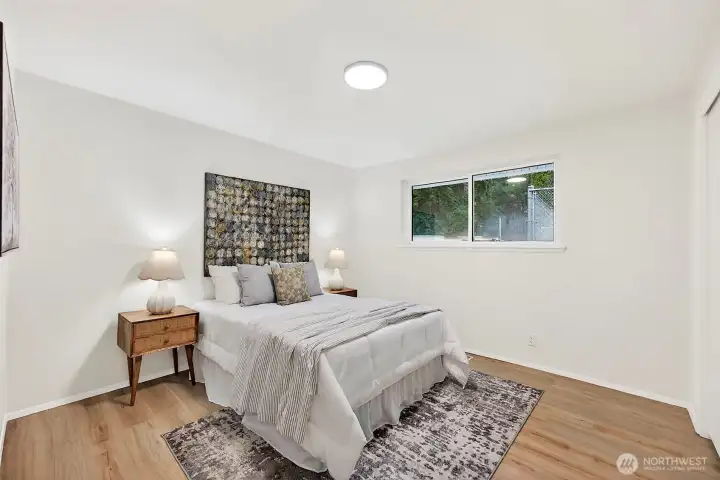 A well-sized fourth bedroom with LVP flooring, a large window with treetop views, and a neutral finish ready for any use.