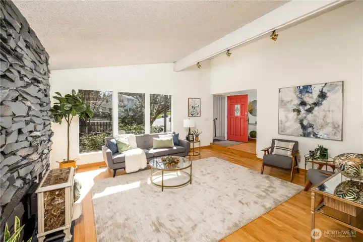 Soaring ceilings and expansive windows define the living room, drawing in natural light and reinforcing a sense of openness.