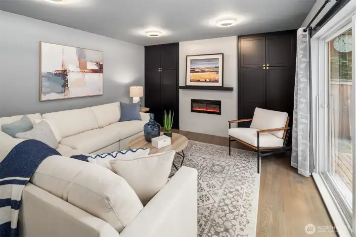 Family room off kitchen with electric fireplace, built-ins on both sides and spot for TV above mantel.