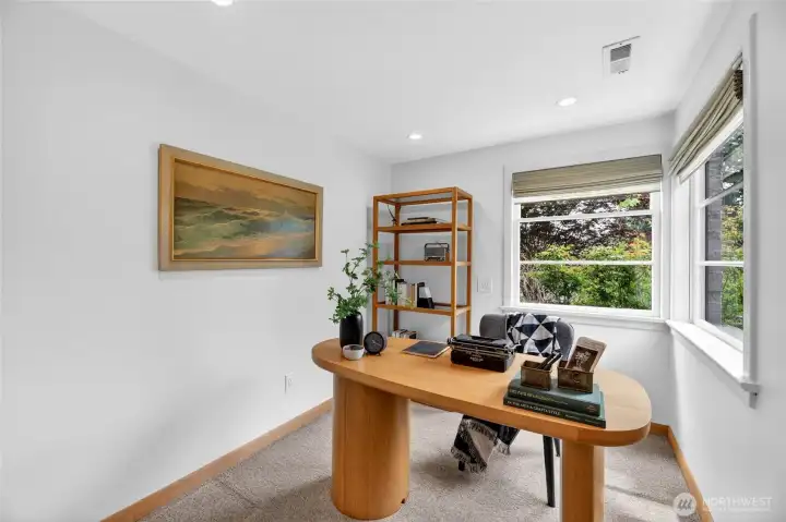 The home office with large windows to take in the peaceful backyard
