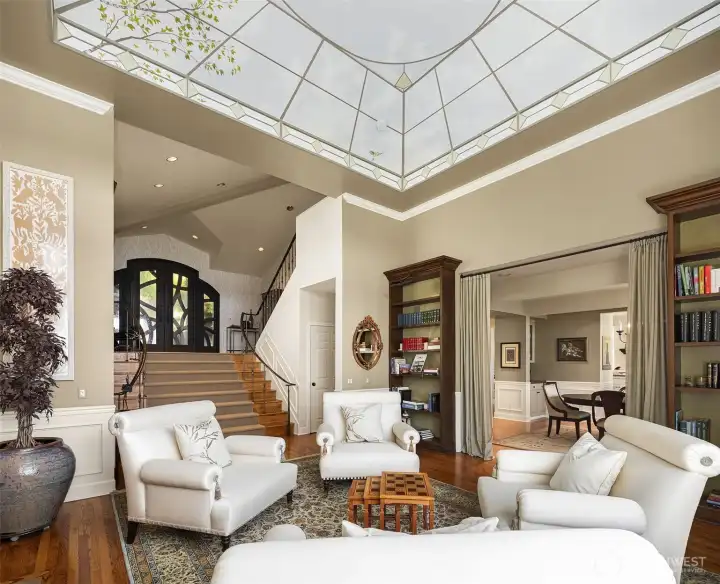 Custom hand-painted ceiling mural elevates this light-filled living space with a truly one-of-a-kind artistic focal point.
