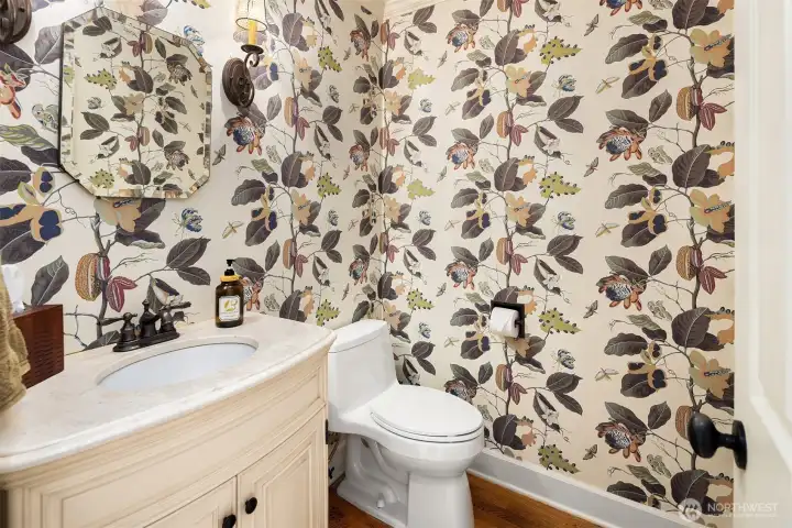 Charming powder room with statement botanical wallpaper and classic vanity detailing.