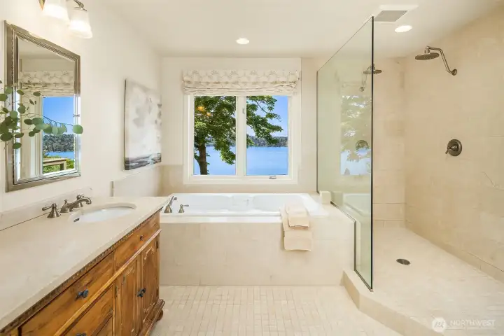 Spa-inspired primary bath with soaking tub, walk-in shower, and tranquil lake views for a true retreat experience.