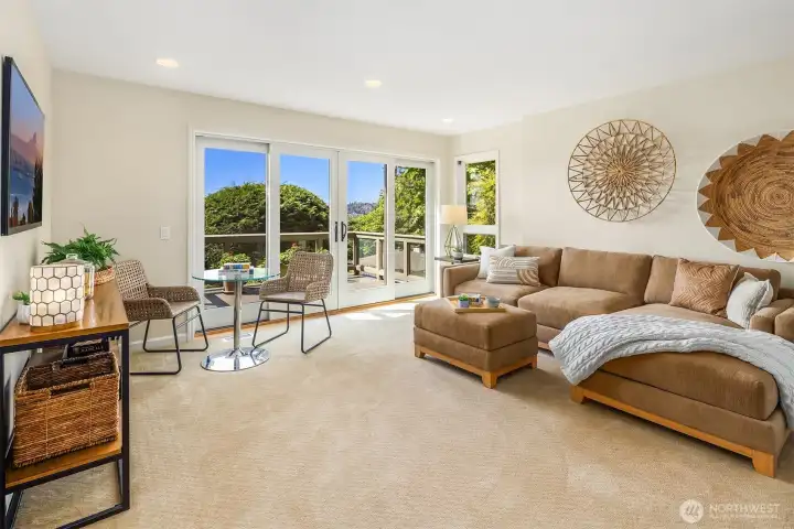 Lower level living with expansive glass doors opening to a private deck and sweeping Lake Washington views. Light-filled and inviting, this flexible space is perfectly suited for media, guests, or relaxed everyday living.