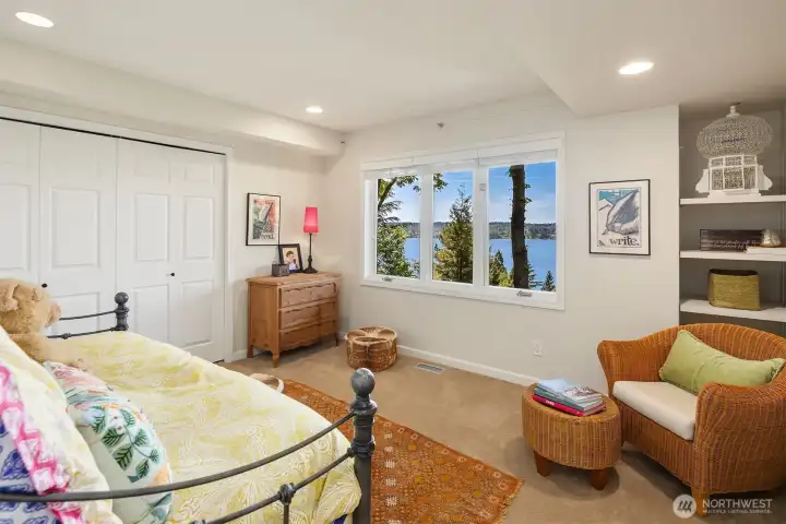 Lower level bedroom framed by tranquil lake views and surrounding greenery—private, peaceful, and ideal for guests or extended stays. A comfortable retreat with just the right balance of light and separation.