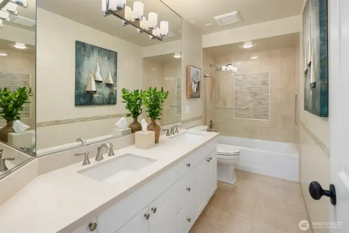 Spacious lower-level bath with dual vanities and a full tub/shower—thoughtfully designed to comfortably serve adjoining bedrooms. Clean lines and neutral finishes create a bright, move-in-ready feel.