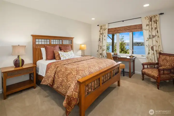 Bright lower level bedroom with a framed lake view and space to spread out. Easy, comfortable, and adaptable—whether set as a sleeping room, workspace, or quiet retreat.