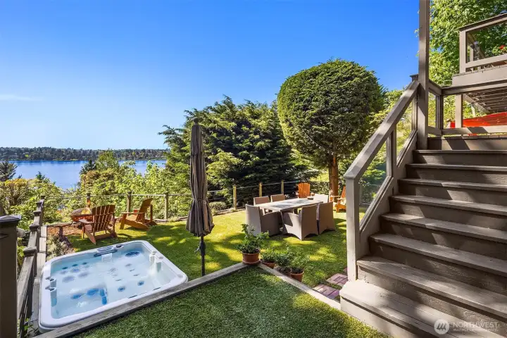 Sunken hot tub, firepit lounge, and dining set against sweeping lake views—an outdoor setting designed for slow mornings, sunset gatherings, and evenings that linger.