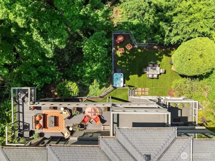 A rare look at the full experience—multiple outdoor living spaces layered from deck to lawn, each thoughtfully designed for gathering, dining, and unwinding in a private, natural setting.