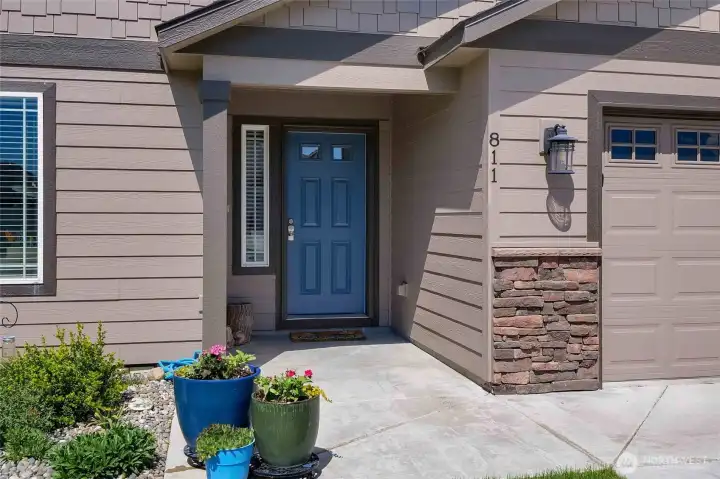 This home features a beautiful blue front entry door and covered doorway to stay out of the sun and keeps your door cool!