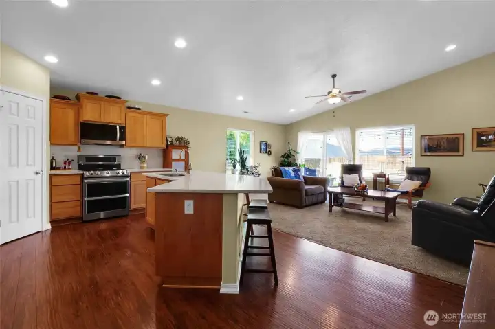 The kitchen and living room offer vaulted ceiling, can lights and stainless steel appliances.  The door on the far left is to the pantry.