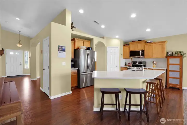 The large island has been updated to a one-level quartz surface for maximum use of space. In the corner by the refrigerator is an espresso/coffee bar area. A coat closet is at this end of the entryway.