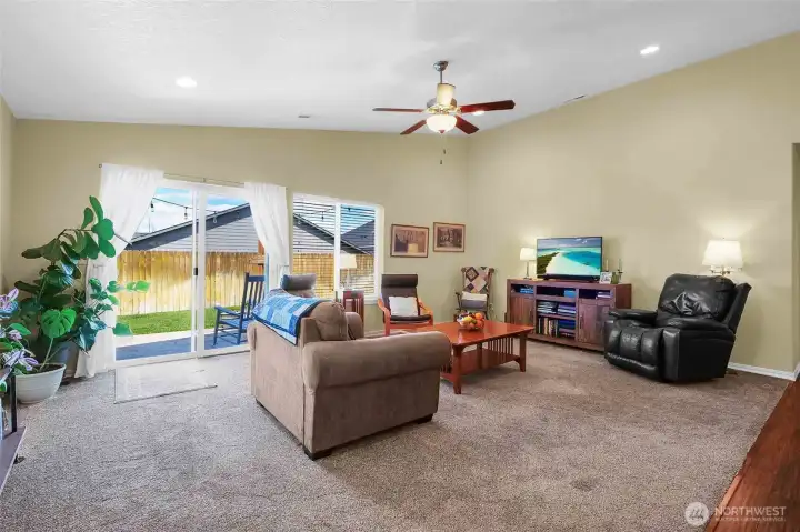 Picture yourself in this cozy living room under the ceiling fan, with your feet up in this well-lit area while the sun shines in!