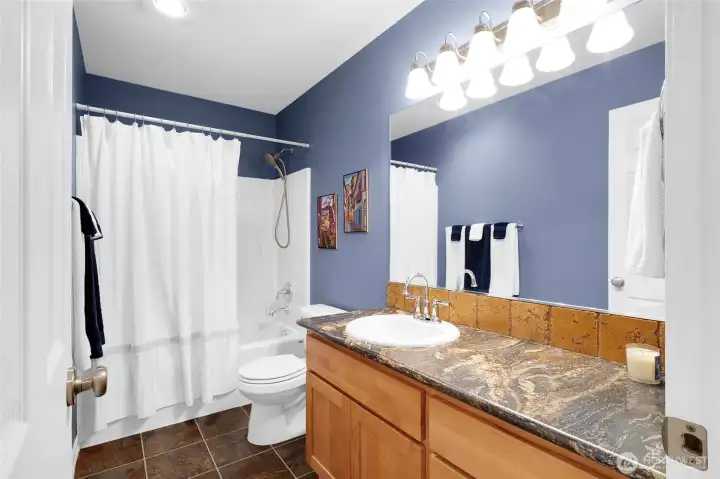 The main bathroom is a full bath, complete with the option of a handheld shower and plenty of cupboards under the counter.