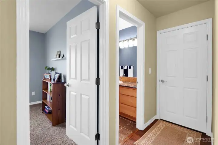 Entries into the third bedroom, main bathroom, and on the right, the door to the garage.