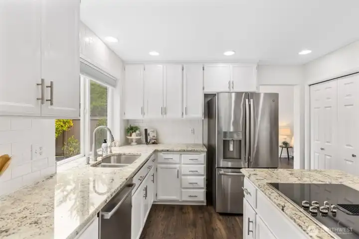 Open-concept kitchen designed for both everyday living and entertaining, featuring quartz countertops, stainless steel appliances, abundant cabinetry, and seamless flow into the main living spaces.