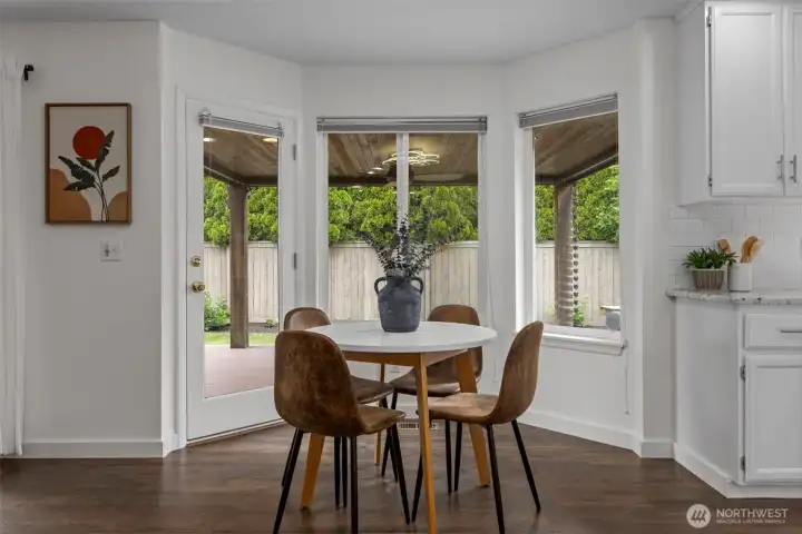 Light-filled breakfast nook overlooking the private backyard with abundant windows and direct access to the covered patio, creating a bright and inviting space to start your day.