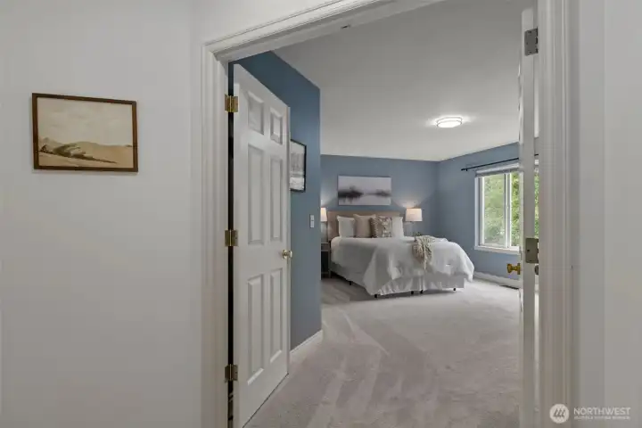 Oversized primary suite featuring elegant French doors upon entry, creating a grand and inviting retreat with plenty of space to unwind and relax.
