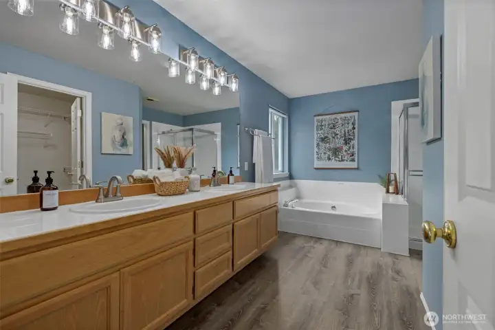 Refreshed 5-piece primary bath featuring a soaking tub, walk-in shower, dual vanity, and a clean, modern aesthetic designed for everyday comfort.