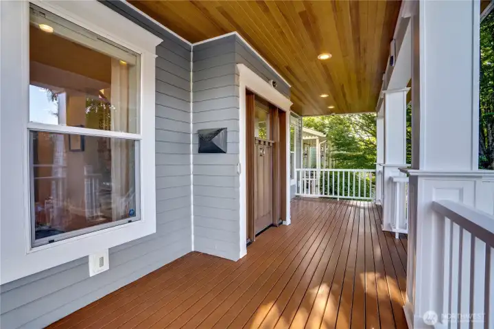 Cedar tongue-and-groove porch ceiling with recessed lighting — a craftsmanship detail that signals the quality of finishes waiting inside. This is the moment between exterior and interior where the home makes its first impression.